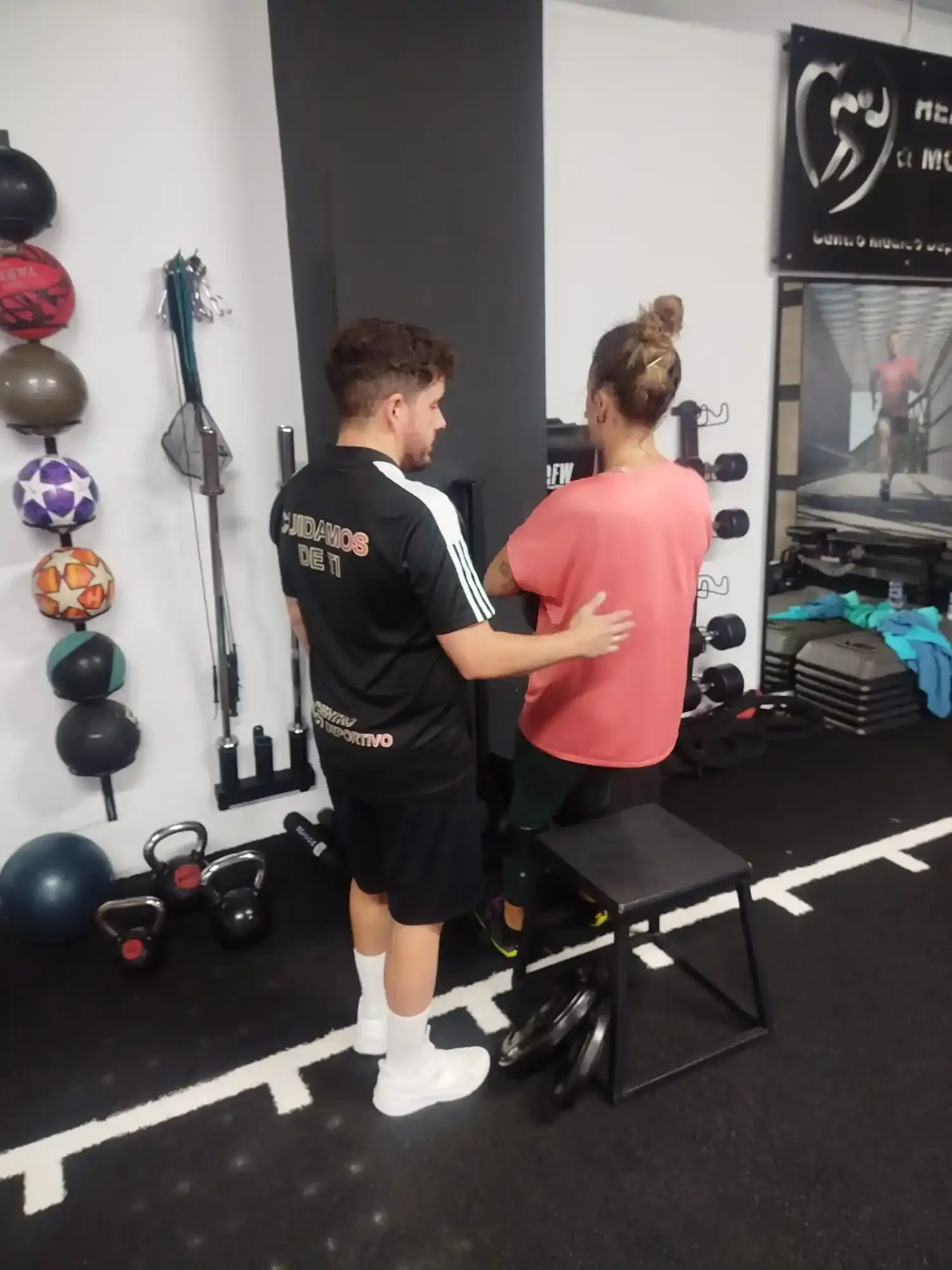 Manu supervisando un ejercicio sentado con una pesa